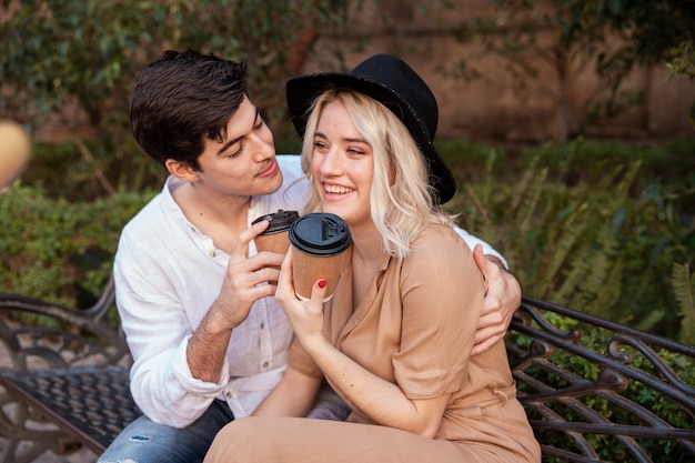 Pareja sonriente en banco en el parque