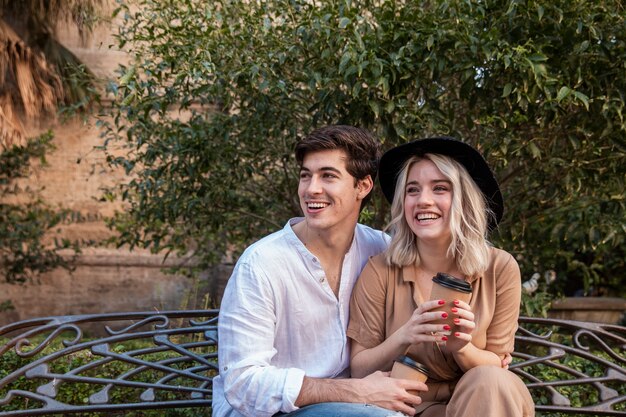 Pareja sonriente en banco en el parque