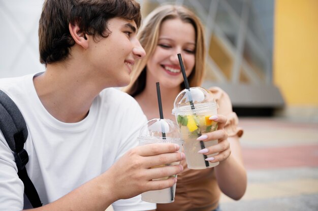 Pareja sonriente con bebidas de cerca