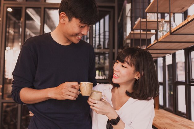 Pareja sonriente brindando con tazas de café