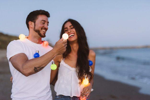 Pareja sonriente con cadena de luz