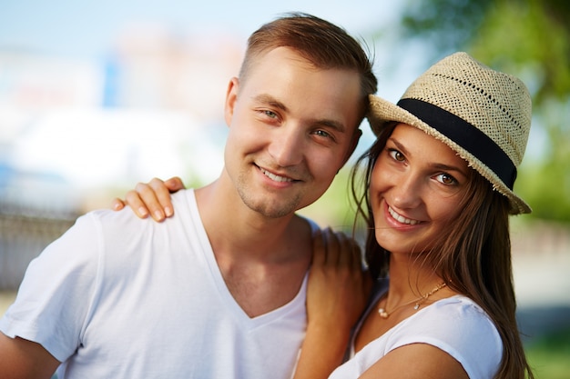 Pareja sonriente caminando por la calle en verano