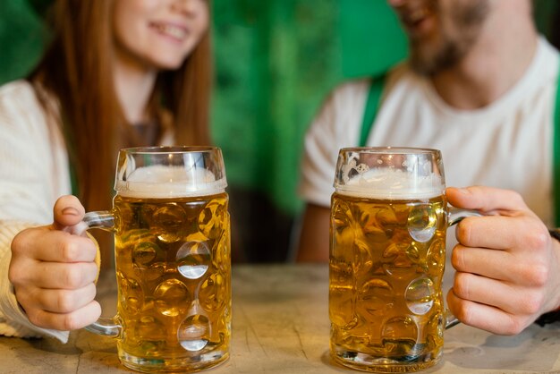 Pareja sonriente celebrando st. día de patricio con bebidas