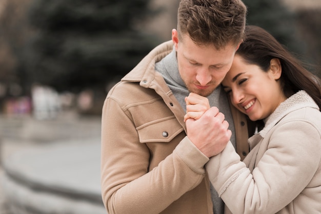 Foto gratuita pareja sonriente cogidos de la mano afuera