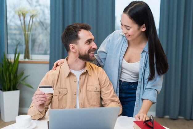 Pareja sonriente disfrutando de una sesión de compras en línea