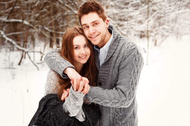 Pareja sonriente divirtiéndose juntos en invierno