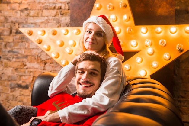 Pareja sonriente enfrente de decoración de estrella de navidad