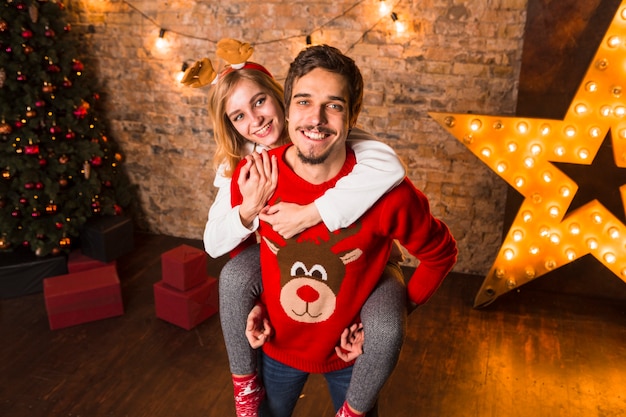 Pareja sonriente enfrente de decoración de estrella de navidad