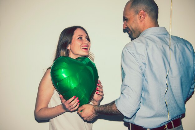 Foto gratuita pareja sonriente con un globo