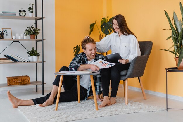 Pareja sonriente haciendo planes para redecorar el hogar