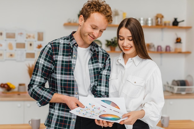 Pareja sonriente haciendo planes para remodelar la casa