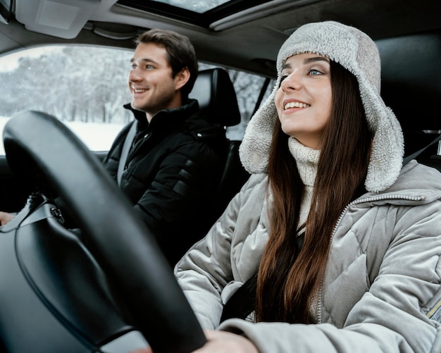 Pareja sonriente juntos en el coche durante un viaje por carretera