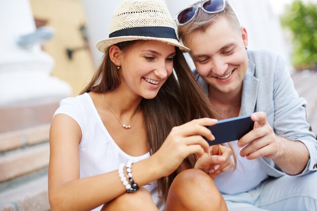 Pareja sonriente leyendo mensajes de texto