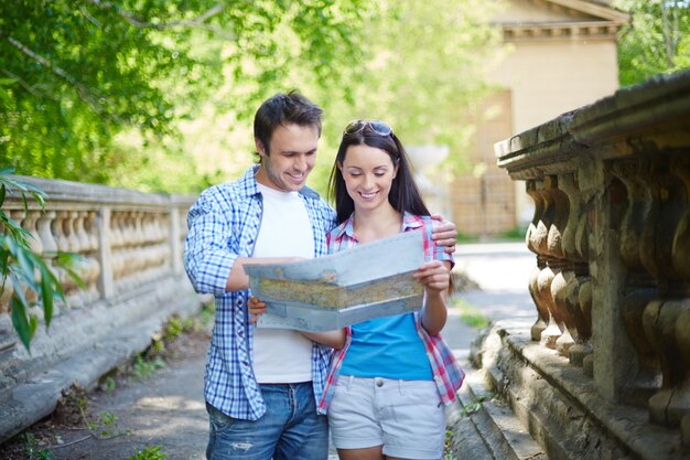 Pareja sonriente mirando un mapa de la ciudad