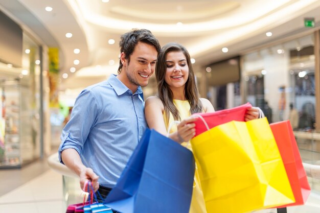 Pareja sonriente mirando ropa nueva