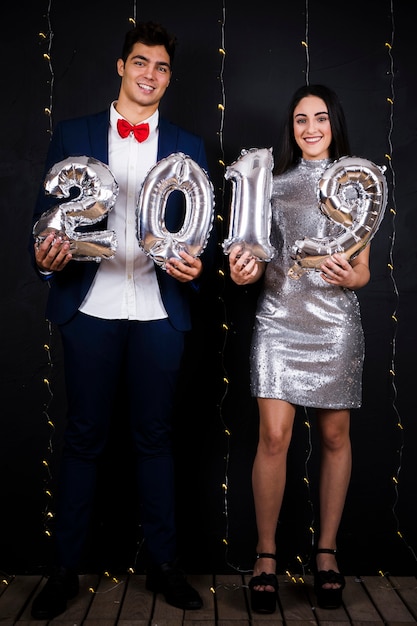 Pareja sonriente con números de globos