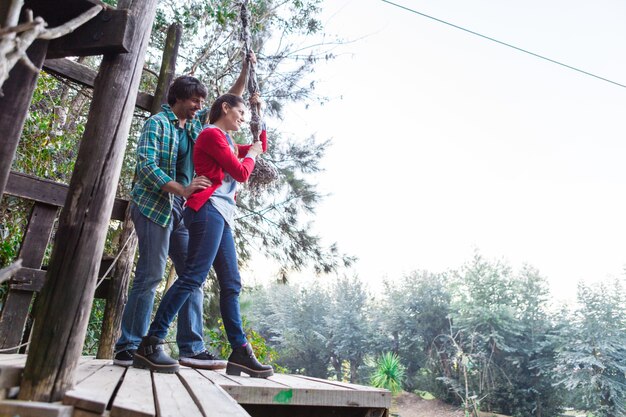 Pareja sonriente pareja en un parque de aventura