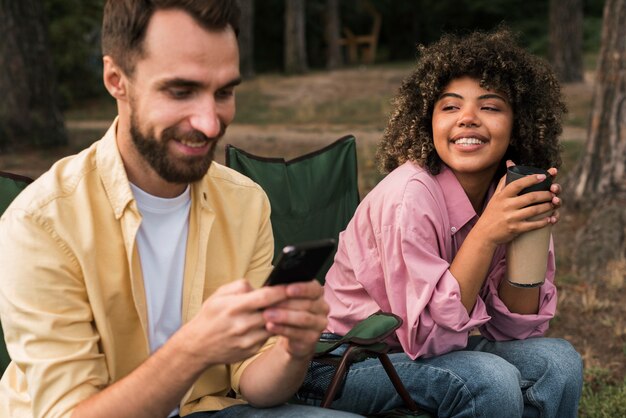 Pareja sonriente pasar tiempo juntos mientras acampa