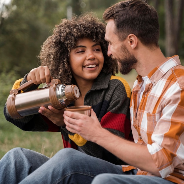 Pareja sonriente pasar tiempo juntos mientras acampa