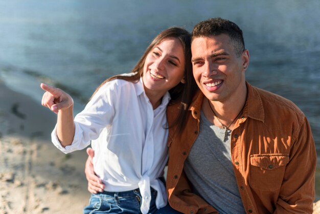 Pareja sonriente pasar tiempo juntos en la playa