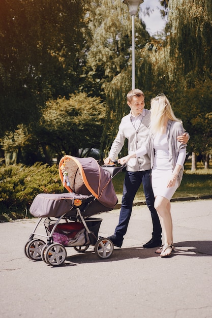 Pareja sonriente paseando a su bebé