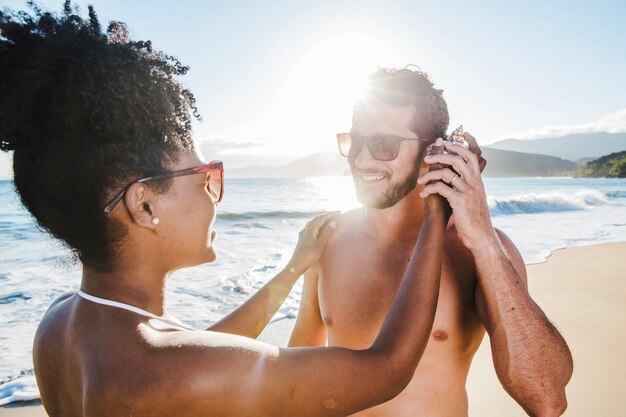 Pareja sonriente poniendo concha en la oreja