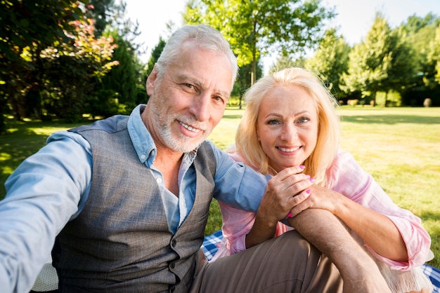 Foto gratuita pareja sonriente posando para la cámara en la naturaleza