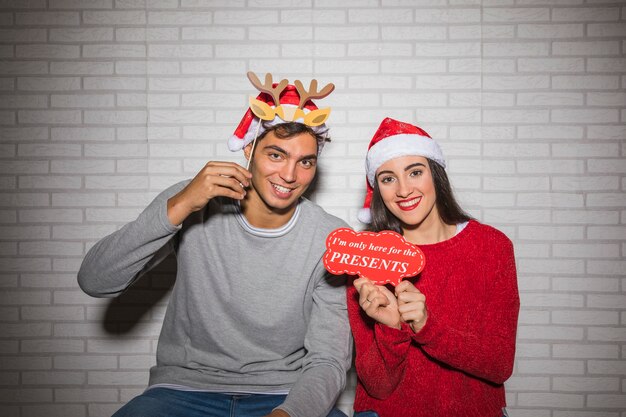 Pareja sonriente posando con decoración de Navidad