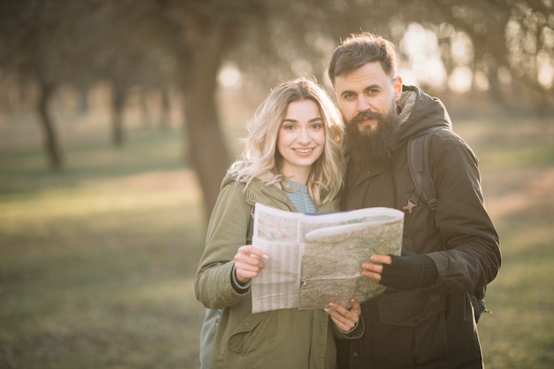 Foto gratuita pareja sonriente posando con mapa