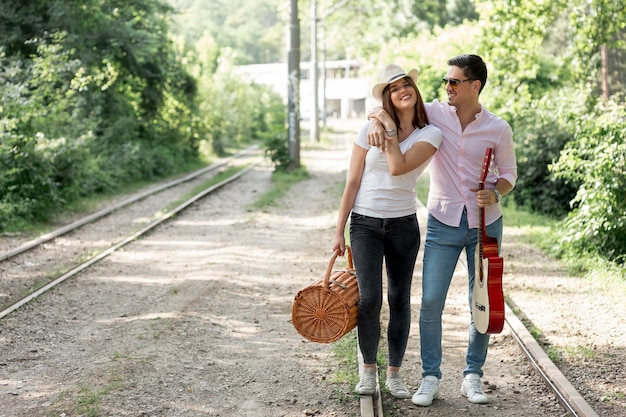 Pareja sonriente, posar, en, ferrocarril