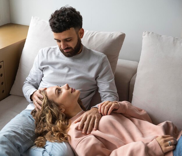 Pareja sonriente relajándose en casa