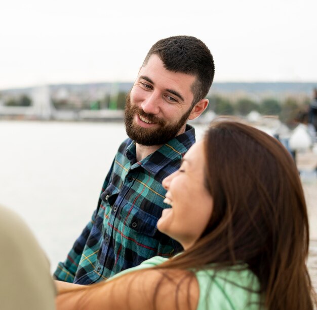 Foto gratuita pareja sonriente sentados juntos al aire libre