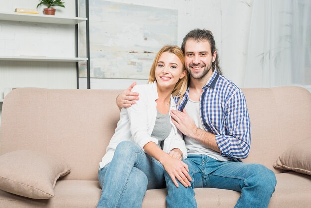 Pareja sonriente en el sofá