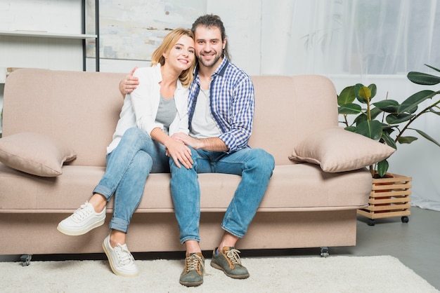 Pareja sonriente en el sofá