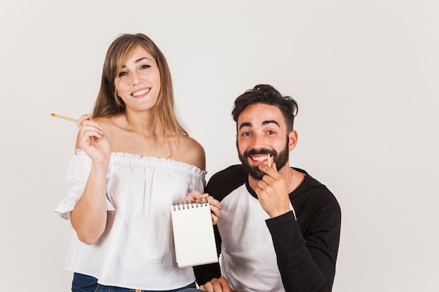 Pareja sonriente sujetando libreta