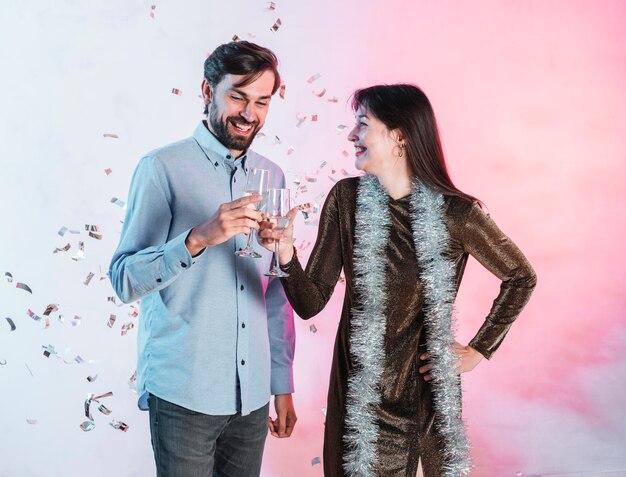 Pareja sonriente tintineando copas de champán