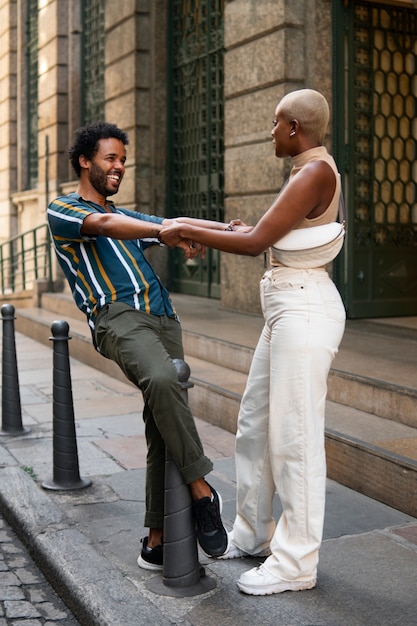 Pareja sonriente de tiro completo al aire libre