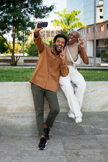 Foto gratuita pareja sonriente de tiro completo al aire libre