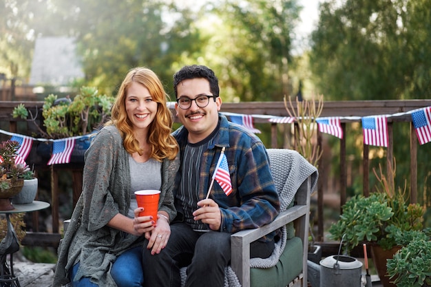 Pareja sonriente de tiro medio con bandera americana