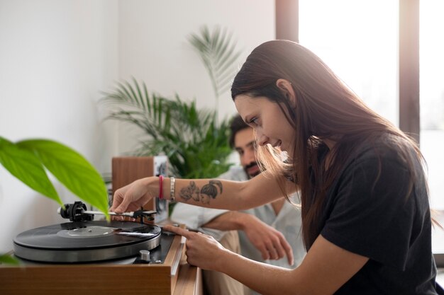 Pareja sonriente de tiro medio con disco de vinilo