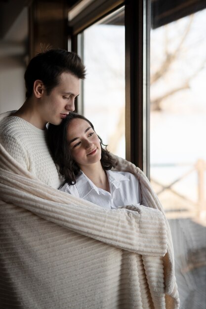 Pareja sonriente de tiro medio con manta