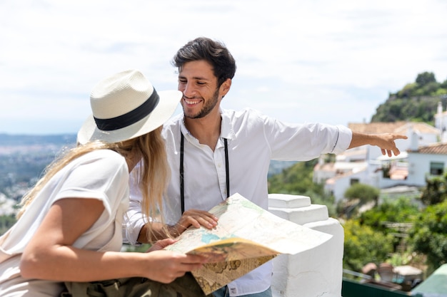 Foto gratuita pareja sonriente de tiro medio con mapa