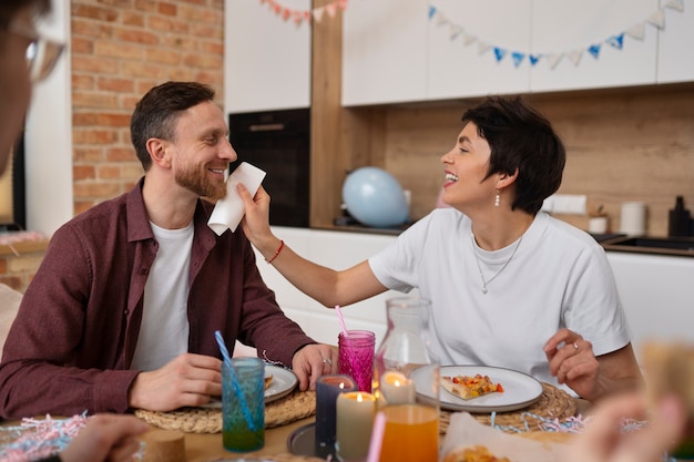 Foto gratuita pareja sonriente de tiro medio en la mesa