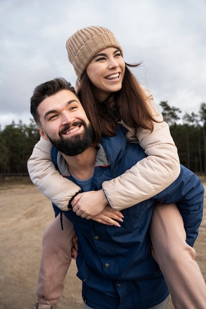 Pareja sonriente de tiro medio en la naturaleza