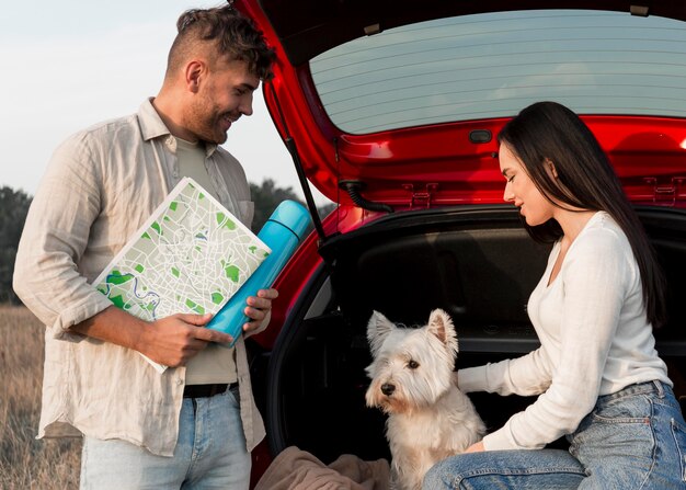 Pareja sonriente de tiro medio con perro