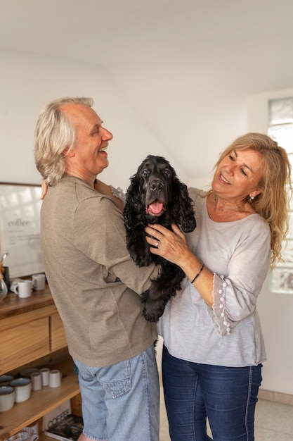 Pareja sonriente de tiro medio con perro