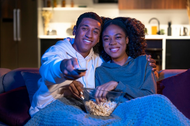 Pareja sonriente de tiro medio en el sofá