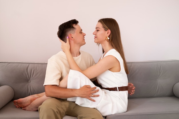 Foto gratuita pareja sonriente de tiro medio en el sofá