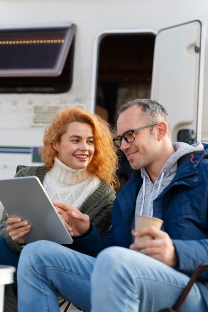 Pareja sonriente de tiro medio con tableta