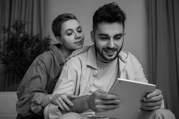 Pareja sonriente de tiro medio con tableta